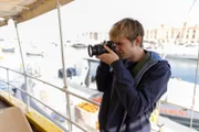 Von Bord aus fotografiert Alex Rider (Otto Farrant) die Küste Maltas – immer auf der Suche nach der nächsten Spur.