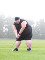 Mike golfing, mid swing.