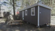 A before shot of the outdated exterior of a cabin at the Country Barn Motel in Nashua, NH, as seen on Travel Channel's Hotel Impossible.