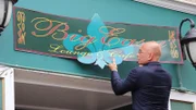 Host Anthony Melchiorri tears down the sign for the Big Easy Lounge, outside the Charles Inn in Bangor, Maine.