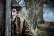 REENACTMENT - Major Lonsdale (gespielt von Jeremy O'Driscoll) hält an der Wand eines Hauses inne.
