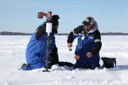 Jeff explains the basics of ice fishing to Eric.