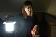 Amy Bruni poses with Boo-Buddy while holding a lantern.