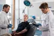 Bernhard Lorenz (Peter Prager, M.) wird von Dr. Marc Lindner (Christian Beermann, l.) und Mikko Rantala (Luan Gummich, r.)  in der Notaunahme behandelt.