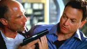 Joe bedroht Detective Mac Taylor mit einer Waffe.