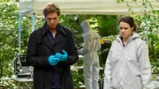 Am Tatort im Wald starren ratlose Ermittler auf den Boden: Thomas Heinze als Caspar Bergmann, Sidonie von Krosigk als Dr. Luisa Geiger