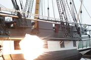 HMS Trincomalee, Hartlepool, UK: Eine Kanonenexplosion an der Außenseite eines Schiffes. In der Schlacht können Kanonen bis zu 32 Pfund wiegen. Die Taktik der britischen Marine bestand darin, so nah wie möglich an den Gegner heranzukommen, idealerweise hinter ihm vorbeizufahren und das Feuer zu eröffnen, um dem Schiff und seiner Besatzung maximalen Schaden zuzufügen.
