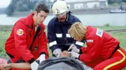 Unterstützt von der Feuerwehr (Mi. Komparse) versorgen Dr. Karin Thaler (Roswitha Meyer) und Florian Lenz (Jo Weil, li.) den schwer verletzten Fahrer eines Lieferwagens des Chemiewerks (Otto Beckmann).