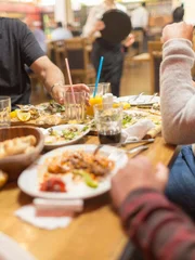 Group of Arab people in restaurant enjoying Middle Eastern Iftar food. Selective focus