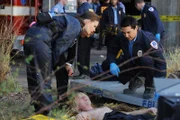 Brennan (Emily Deschanel, l.) und ein Sanitäter (Kurt Caceres, r.)versuchen den Untergrundkünstler Seth (Jay Paulson) von den ziemlich verwesten Überresten einer männlichen Leiche zu befreien.