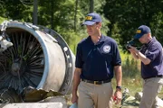REENACTMENT - NTSB Investigator Joe Sedor (played by Jason Faulkner) walks through the crash site of Comair Flight 5191, while a NTSB Crash Investigator photographs the wreckage.