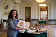 Bettany Hughes hält das Gedichtband Nizamis`s im Institut der Manuskripte.