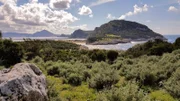Die Ochsenbauchbucht bzw. Voidokilia. Der Strand zählt zu den schönsten des Peloponnes bzw. von ganz Griechenland. Die Bucht mit ihrem feinen Sandstrand ist fast kreisrund und öffnet sich lediglich zum Meer hin. Die relativ kleine Öffnung zum Meer ist zu beiden Seiten von Felsen begrenzt.