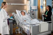 Nach der OP wird Pia (Lilith Häßle, M.) von ihrer Chefin und Freundin Fadia Darzi (Nagmeh Alaei, r.) besucht. Julia Berger (Mirka Pigulla, l.) ist zufrieden. Ihrer Patientin geht es schon besser.