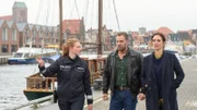 Frühmorgens führt Polizistin Paula Moorkamp (Stella Hinrichs, l.) ihre Kollegen Karoline Joost (Nike Fuhrmann, r.) und Lars Pöhlmann (Dominic Boeer, M.) durch den Wismarer Hafen zum Fundort der Leiche. Der zukünftige Bräutigam, Benjamin Flemming, wurde tot im Hafenbecken aufgefunden. Paula ist bereits in Wismar gut vernetzt und kann ihre Kollegen unmittelbar mit wertvollen Informationen versorgen, denn in diesem Fall laufen viele Interessen gegeneinander.