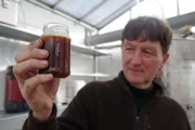 Joachim Böttcher mit einem Cocktail aus Mikroorganismen für die Terra Preta.