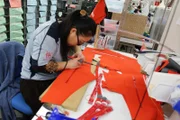 Goretex factory, woman cutting material.
