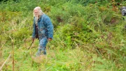 Billy Brown  walks through the field.