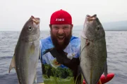 Eric holding two fish.