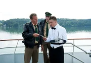 Johannes Staller (Helmfried von Lüttichau, M.) und Franz Hubert (Christian Tramitz, l.) zeigen dem Kellner Robert Sachs (Maximilian Berger, r.) ein Foto der Toten.