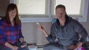 Amy Bruni looks away while listening to an EVP recording; Adam Berry holds the recorder.