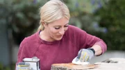 Host Jasmine Roth applies oil to a 200 year old olive burl coffee table, as seen on HGTV's Hidden Potential.