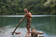 Ed Stafford on a raft in the Landon sink hole holding a fashioned quant pole in both hands in Guatemala.