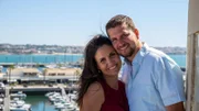 Sandra Miller (L) and Dwight Miller (R) standing on a viewing terrace with marina in Cascais, Portugal in the background, smiling to the camera and being happy about their new life in Portugal, as seen on Mediterranean Life (portrait)