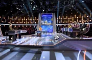Moderatorin Esther Sedlaczek (M.) mit den Kandidat:innen des Teams "Kamera": Dem Schauspieler Jörg Hartmann (l.) und der Schauspielerin Aylin Tezel (2.v.l.), sowie dem Quizduell-Olymp-Rateteam: Marie-Louise Finck (3.v.r.), Eckard Freise (2.v.r.) und Thorsten Zirkel (r.).