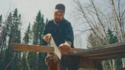 Billy schneidet Holzbalken mit einer Handsäge