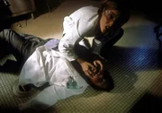 Scully (Gillian Anderson, oben) kümmert sich um die Gerichtsmedizinerin (Tara Karsian), die während einer Autopsie plötzlich Nasenbluten bekommen hat.
