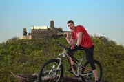 Martin Busch (Gerrit Klein) posiert für Fotos vor der Wartburg in Eisenach.