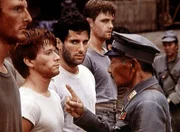 Ben (Eric Scott, 2.v.l.) und Norman (Jordan Suffin, 3.v.l.) werden von dem japanischen Kommandeur (Jerry Fujikawa) dabei überrascht, als sie in dem Gefangenenlager die amerikanische Flagge hissen.