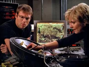 Carter (Amanda Tapping) versucht das demulierte Flugobjekt zusammen zu setzen. Daniel (Michael Shanks) hilft ihr mit seinem Übersetzungswissen...
