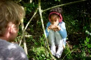 Paul (Daniel Roesner) findet im Wald das kleine Mädchen (Nomie Laine Tucker), apathisch auf die Musik aus ihren Kopfhörern lauschend.