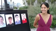 Manhattan, New York - Model smiles at Face Value game board showing 4 out of 5 male faces that will be ranked by volunteers in order of attractiveness to demonstrate the idea that people's brains are able to discern facial beauty in as little as 10 seconds.