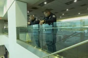 Miami, FL - CBP Officer David Saavedra and Adriel Rimola observe over upper level of staircase for any suspicious passengers. (National Geographic/Lucky 8 TV)