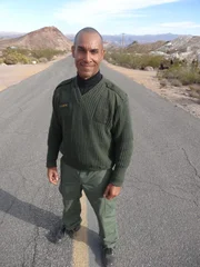 Nelson, Nevada - Retired Sgt. Chris Curtis standing on road for Crash Witness game, during which he re-wires participating witnesses' recollection of a car accident by targeting their brain’s memory manager, the hippocampus.