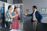 Controller Donato (Paul Brusa, r.) erklärt Hartmut (Georg Veitl, l.) und Annegret Nerlinger (Eva Wittenzellner, M.), dass sie nur ein begrenztes Übernachtungsbudget zur Verfügung haben.