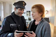 Die verwirrte alte Dame, Frau Ohmke (Renate Schroeter, r.), zeigt Tarik (Serhat Cokgezen, l.) alte Familienfotos.