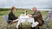 Rechtsmedizinerin Helene Sturbeck (Katharina Blaschke, l.) hat es geschafft: Sie hat ihren Kollegen Jan-Hinrich Reuter (Udo Kroschwald, r.) endlich zu einem Ausflug an die Küste überreden können. Ziel der Landpartie ist ein Restaurant namens "Küstenkieker", dass ŕ la carte für Wohnmobilisten serviert – im Grünen und auf Campingstühlen. Doch die Freude über den Zander währt nicht lang: Ein Gast findet in der Nähe eine Leiche im Wasser.