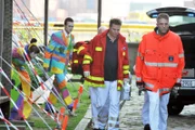 Notarzt Haase (Fabian Harloff, 2.v.r.) und seine Kollegen (Komparse) werden zu einem Einsatz in einem besetzten Haus gerufen, in dem auch Lilly (Lore Richter, l.) und Tim (Eric Klotzsch, 2.v.l.) sich aufhalten.