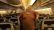 Stephanie geht durch die Gänge eines Flugzeugs.