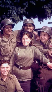 US-Soldaten posieren mit einer Angehörigen der Roten Armee: Zusammentreffen von US-Armee und sowjetischen Truppen in Torgau an der Elbe am 27.04.1945, (1. US-Armee / 5. sowjetische Garde-Armee).