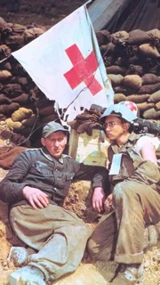 Am 27. April 1945 trafen US-Einheiten und die Rote Armee auf deutschem Boden zusammen. Die Doku zeigt, wie sich die Wehrmacht in diesem Teil Nazideutschlands auflöste und wie sich Hunderttausende deutsche Soldaten in amerikanische Kriegsgefangenschaft begaben. (Foto: Gefangener Wehrmachtssoltat und verwundeter US-Soldat)