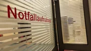 Ep2 - a glass window with the German word for ER (Notfallaufnahme) on it and stripes to provide some kind of privacy.