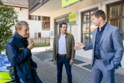 Vor der OBB-Bank besprechen Polizeihauptmeister Mohr (Max Müller, l.), Kommissar Kaya (Baran Hêvî, M.) und Kommissar Hansen (Igor Jeftić, r.) die aktuellen Ermittlungsergebnisse im Mordfall des Bank-Filialleiters Dr. Aumüller.
