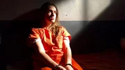 Shawna Nelson (Pamela Portnoy) sitzt mit Handschellen in einer Gefängniszelle.