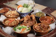 Das Khan Toke-Abendessen bietet eine Auswahl an traditionellen Lanna-Gerichten wie Curry-Schweinebauch, Tomaten- und Schweinefleisch-Dip, gebratenes Huhn und andere nordthailändische Spezialitäten.