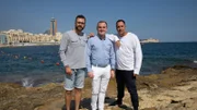Adam Thomison (R) with his friend Milos Sarac (L) and Colin Porter Johnson (C), the realtor, standing at the waterfront in the area of Sliema, Malta, as seen on Mediterranean Life